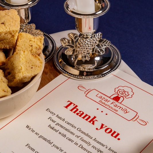 Candlesticks and a bowl of mandel bread on a table set for a break-fast gathering